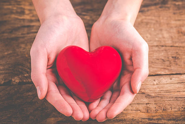 istock with heart in hands - giving love 627873478