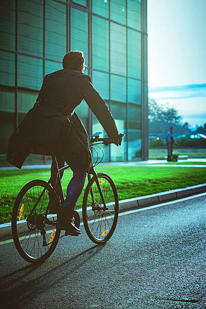 istock Handsome man riding bicycle beside the modern office building 627885914