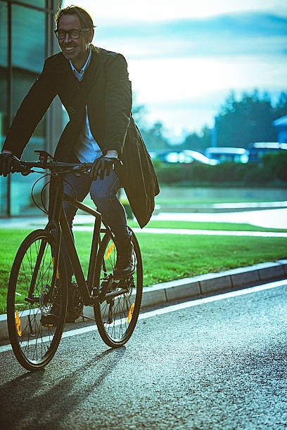 istock Handsome man riding bicycle beside the modern office building 627887334