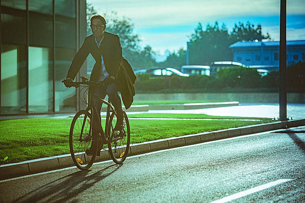 istock Handsome man riding bicycle beside the modern office building 627887634
