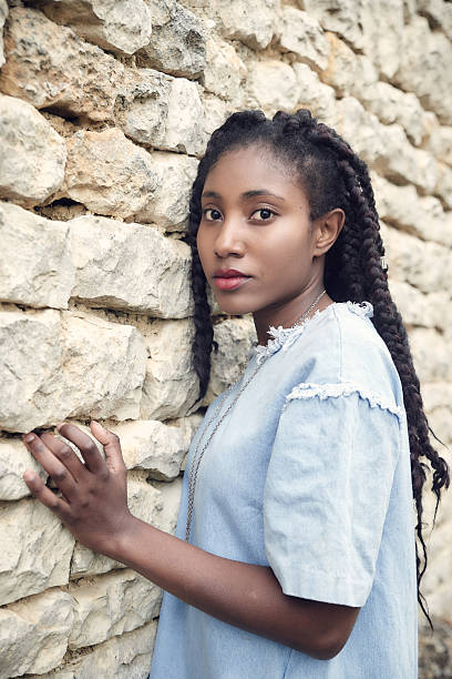 istock Beautiful black woman posing - hands on wall 627888044