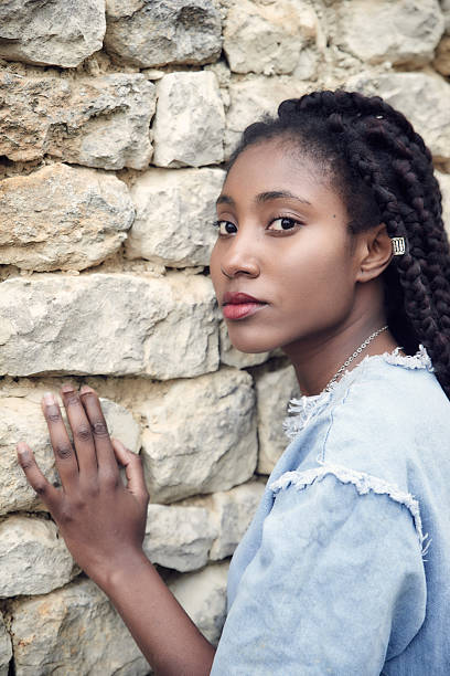 istock Beautiful black woman posing - hands on wall 627888100
