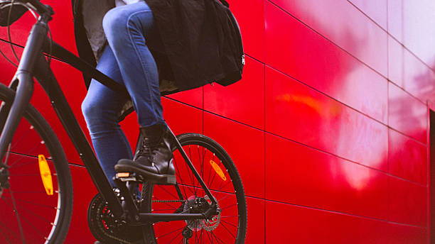 handsome man riding bicycle beside the red wall - cycling bicycle hipster urban scene imagens e fotografias de stock