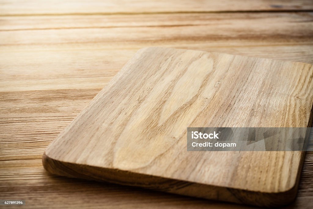 Bright cutting board on a background of the wooden table Kitchen Stock Photo