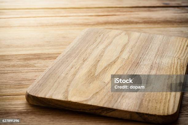 Bright Cutting Board On A Background Of The Wooden Table Stock Photo - Download Image Now