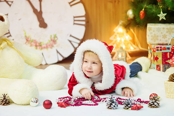 Little boy in a Christmas tree with gifts stock photo