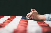 istock Hands praying over USA flag 627909398