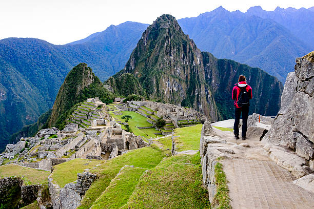 Woman overlooking the Inca ruins of Machu Picchu stock photo