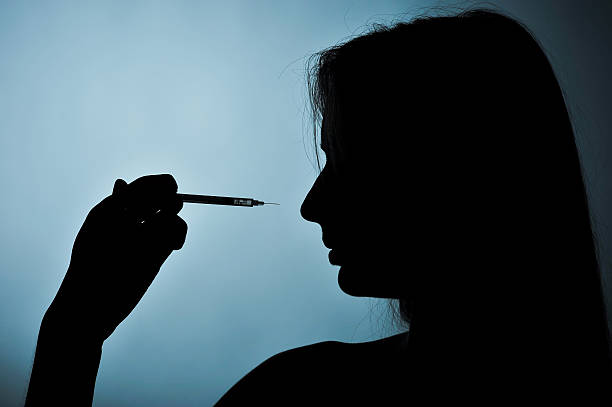 istock syringe and girl silhouette on a blue background 627914570