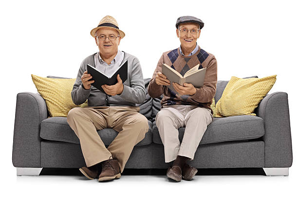 istock Two mature men with books sitting on a couch 627914630