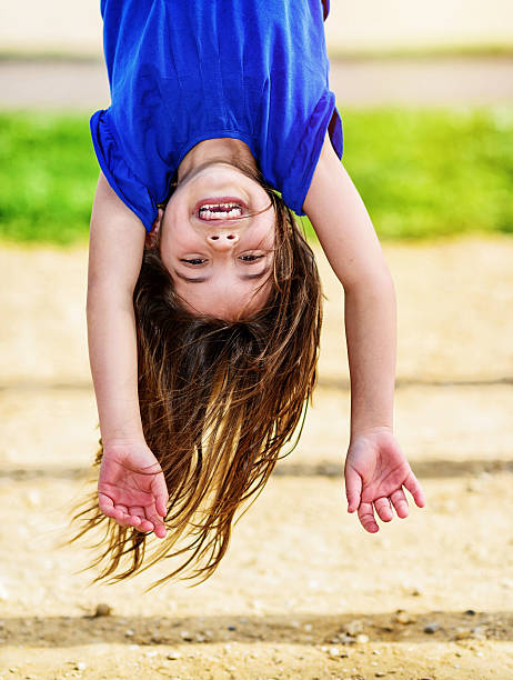 kid hanging upside down on the monkey bars - child jungle gym playground laughing imagens e fotografias de stock