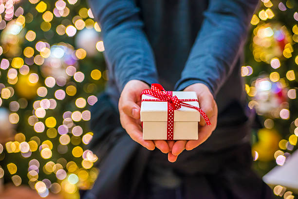 istock Man holding a gift box, giving someone present 627916686