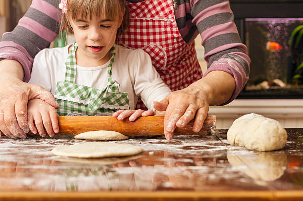istock Grandma and granddaughter stretching dough 627917014