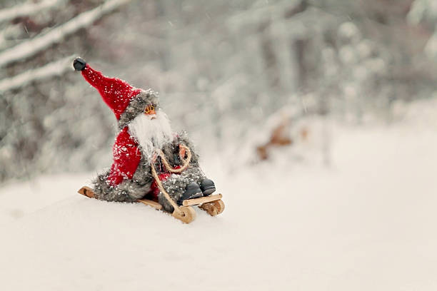 istock Toy Santa Claus on a sledge in a snowy forest 627917676