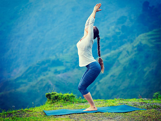 femme faisant yoga asana utkatasana en plein air - salutation au soleil photos et images de collection
