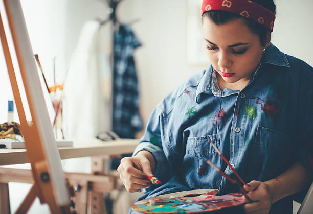 istock Young girl paints on canvas 627924208