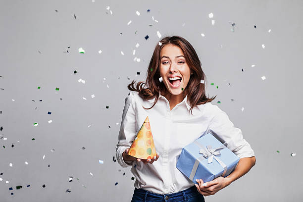 istock Laughing girl with falling confetti at party 627933720