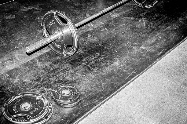 Bodybuilding exercise equipment weight plates. Gym floor. Selective focus. Dark image. Hard contrast.
