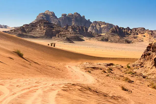 Stock photo of a desert road leading through the  Wadi Rum Desert also known as the Valley of the Moon, a UNESCO World Heritage Site in Jordan.