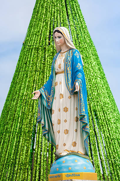 Virgin Mary Statue with Christmas Tree Background.