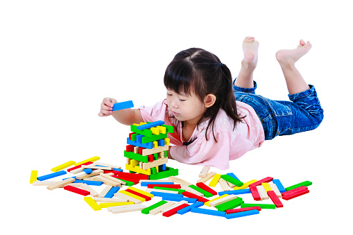 Happy asian child. Pretty girl playing toy wood blocks, isolated on white background. Educational toys for kindergarten child. Strengthen the imagination of child. Studio shot.