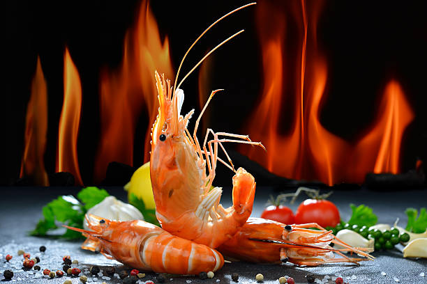 istock Cooked shrimps,prawns with seasonings on flame background 627949704