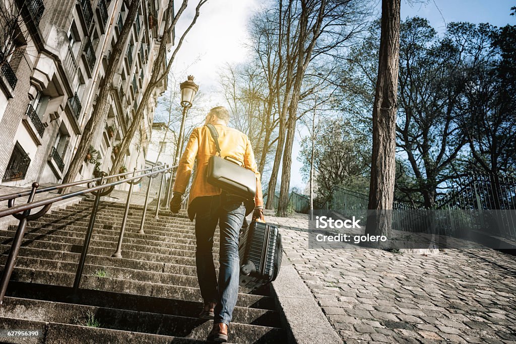 bearded man with suitcase stepping up monmartre stairs in paris Men Stock Photo