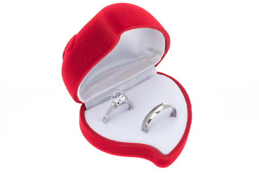 Two wedding rings in a heart shaped ring box