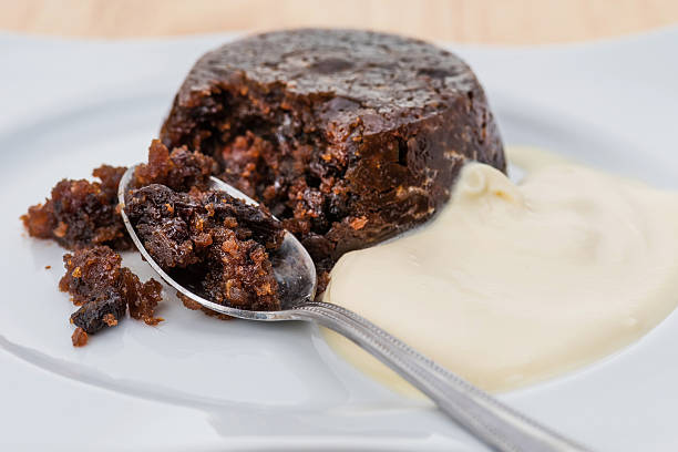 Christmas pudding and cream An individual Christmas pudding with thick cream christmas pudding stock pictures, royalty-free photos & images