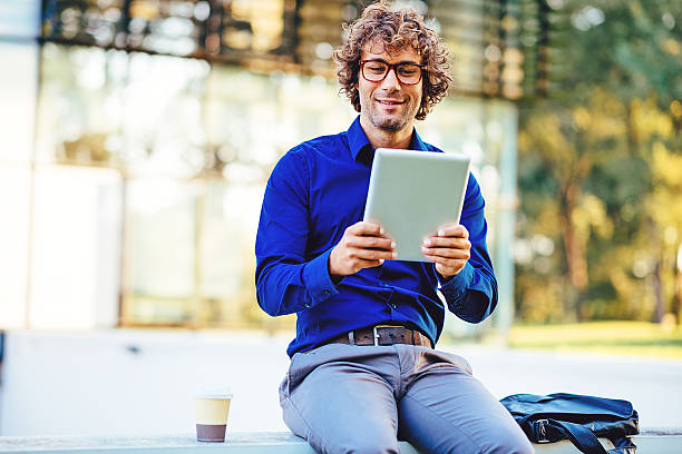 istock Intelligent young businessman with glasses using digital tablet 627957580