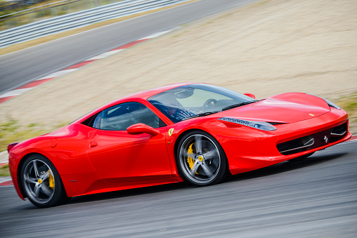 Saint Gotthard Pass, Switzerland - September 13, 2019: Red supercar Ferrari 458 Italia at the high mountain Alpine road.