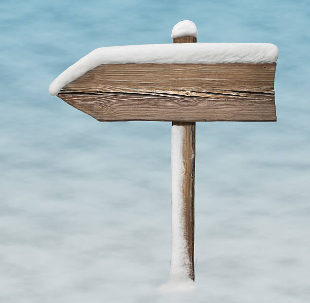 istock Wooden direction sign with less snow on it on snowbackground 627967230