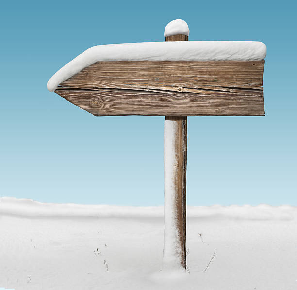 istock Wooden direction sign with less snow with sky on background 627967524
