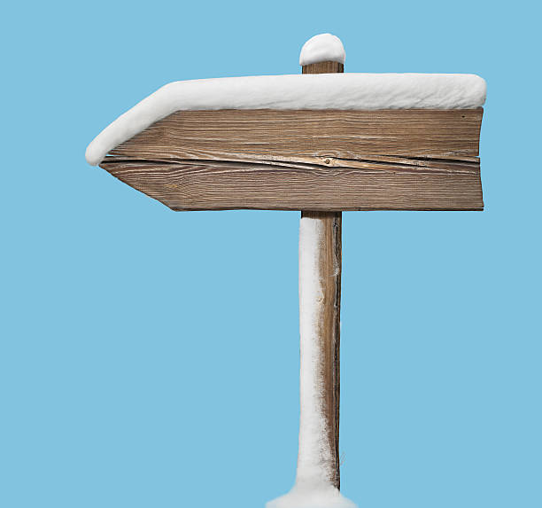 istock Wooden direction sign with less snow isolated on blue 627968070
