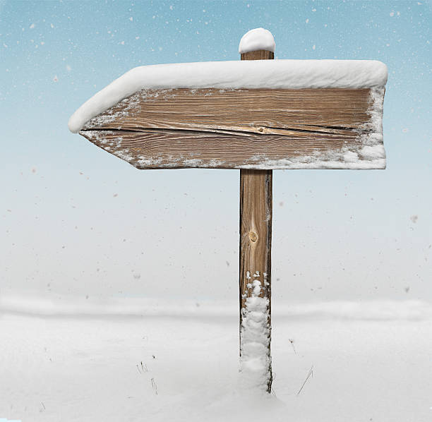 istock Wooden direction sign  with snowfall on background 627968964