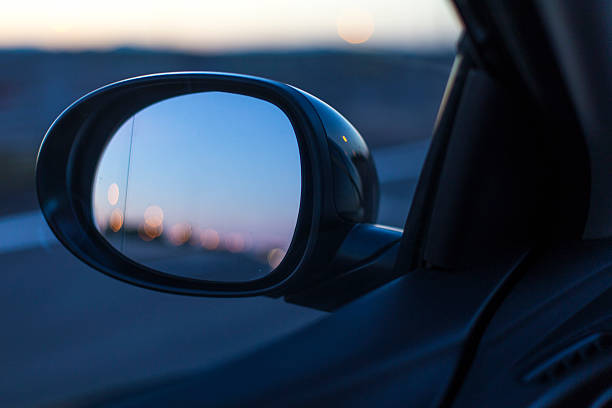 istock Left mirror car on a blue sunset road scene 627974356