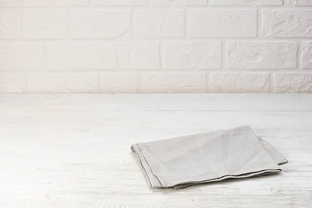istock Gray napkin isolated on white wooden table. Copy space. Brick 627974506