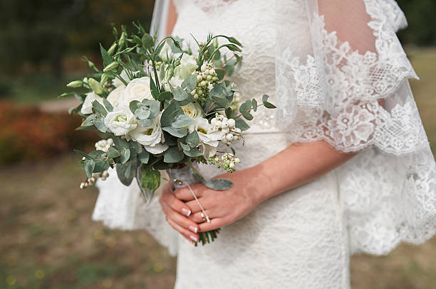 istock bride holding a bouquet of white roses 627986232