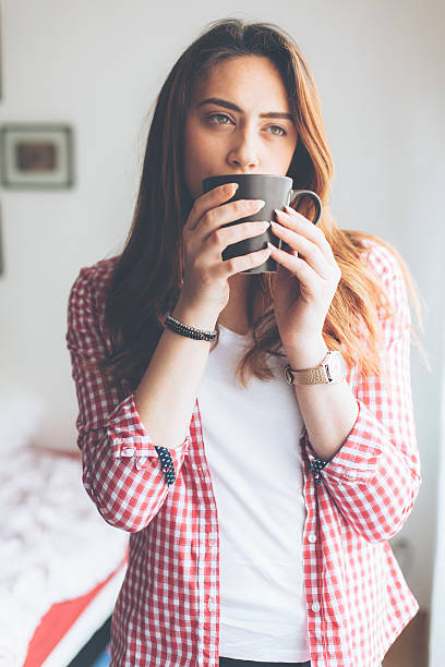 istock Young woman drinking tea at home 627986360