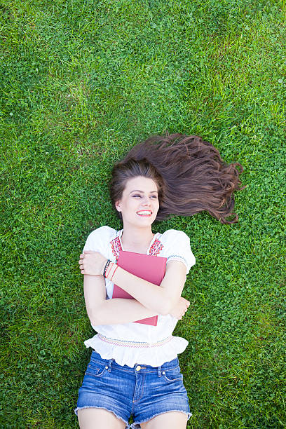 istock Smiling young woman embracing a book 627986738