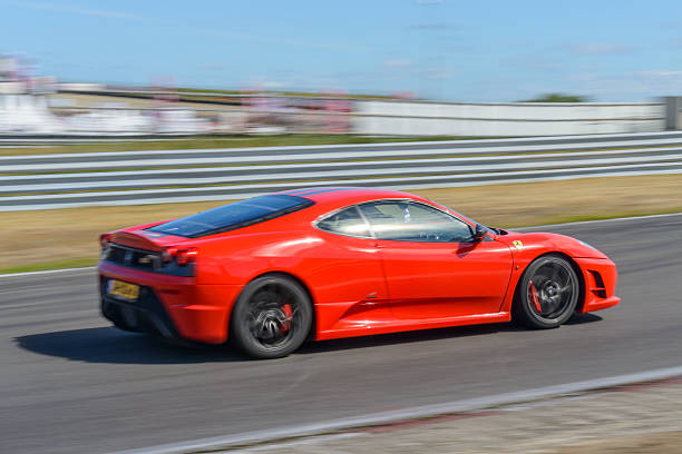 Ferrari F430 Scuderia Italian V8 sports car driving fast Zandvoort, The Netherlands - June 29, 2014: Ferrari F430 Scuderia sports car driving on the Zandvoort race track during the 2014 Italia a Zandvoort day. ferrari ferrari f430 italian culture action stock pictures, royalty-free photos & images