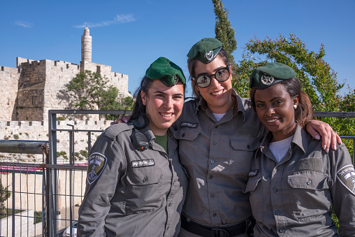 Jerusalem, Israel - may 03, 2015: Three young women in military uniforms in front of the tower of David and the old city walls