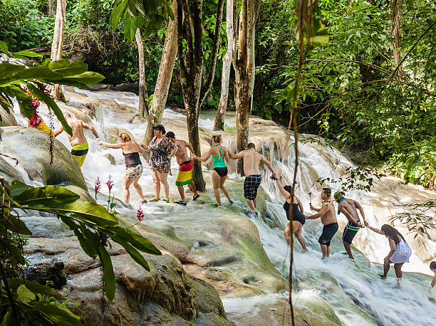 The Dunn's River Falls in Jamaica. Ocho Rios, Jamaica - November 15, 2016: The Dunn's River Falls are waterfalls in Ocho Rios in Jamaica, which can be climbed by tourists. dunns river falls stock pictures, royalty-free photos & images