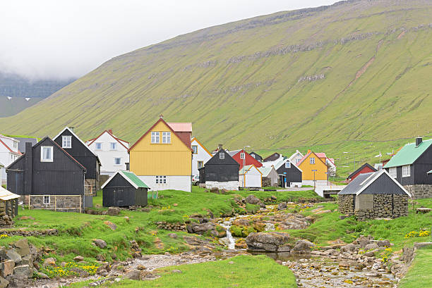 Picturesque village of Gjogv (Faroe Islands) with typically colourful houses Picturesque village of Gjogv with typically colourful houses and the smaal creek on the island of Eysturoy, Faroe Islands, Denmark green valley denmark stock pictures, royalty-free photos & images