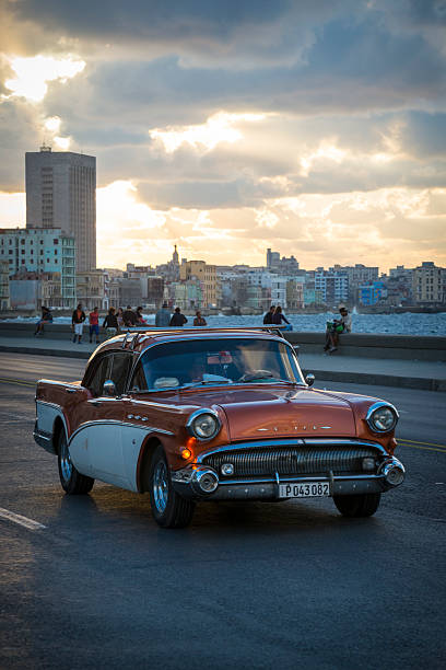 Havana, Cuba - January 15, 2016: Night scene with very little light of a taxi picking up passengers on a major avenue in the city center