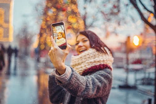 Woman taking selfie in front of the christmas tree
