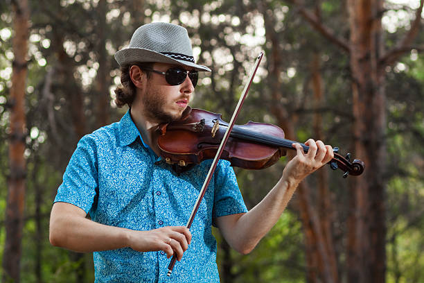 istock Professional musician playing the violin in the forest 628016612