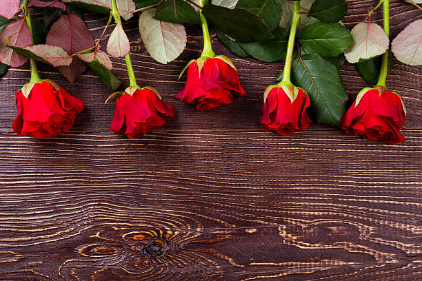 istock Red roses on wooden background. 628017720