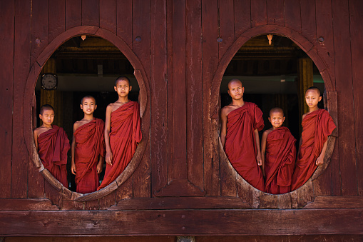 Novice Buddhist monks looking out of the window at Shwe Yan Pyay Monastery (Shwe Yaunghwe Kyaung Monastery) , Nyaung Shwe , Myanmar (Burma)