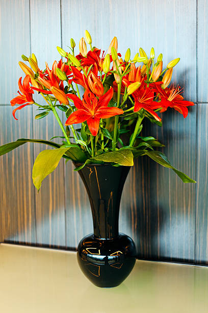 istock red lilies in black vase 628023922